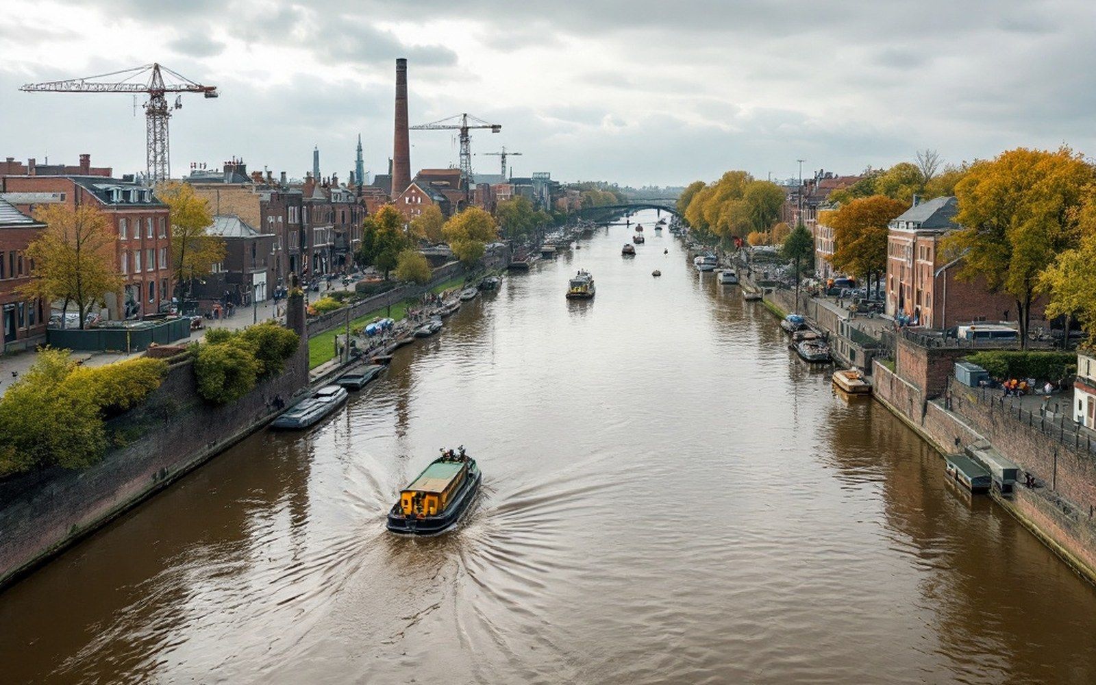 A wide slow brown river with a low far bank and a flat sky, no boats